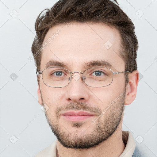 Joyful white young-adult male with short  brown hair and grey eyes