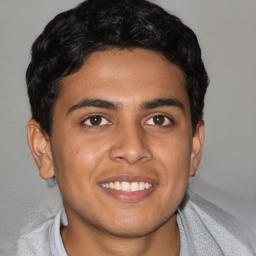 Joyful latino young-adult male with short  black hair and brown eyes