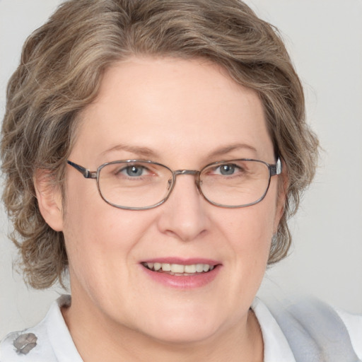 Joyful white adult female with medium  brown hair and blue eyes