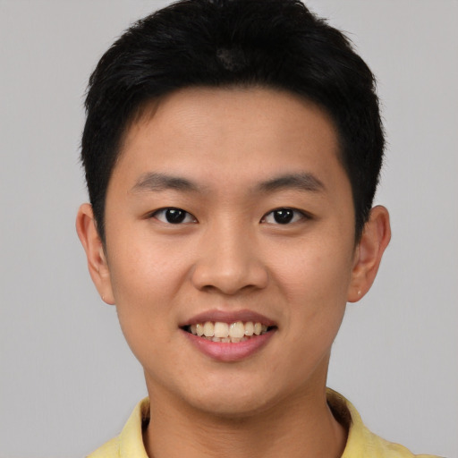 Joyful asian young-adult male with short  black hair and brown eyes