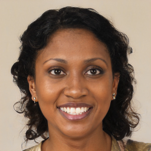 Joyful black young-adult female with long  brown hair and brown eyes