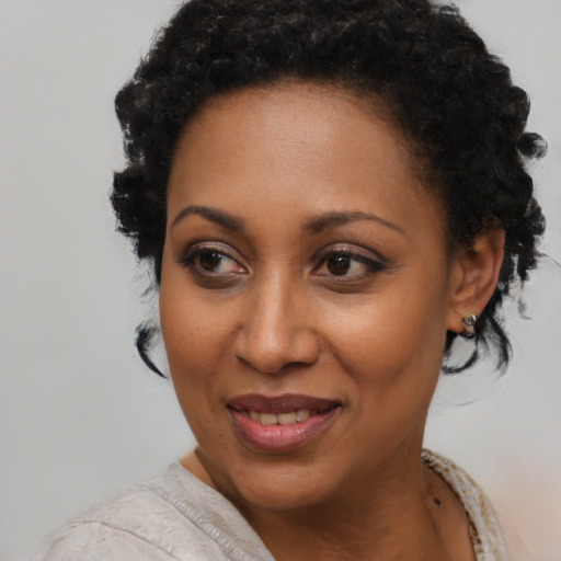Joyful black young-adult female with short  black hair and brown eyes