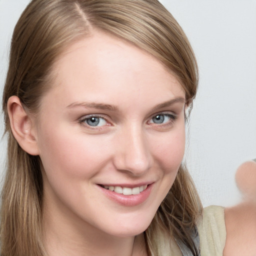 Joyful white young-adult female with long  brown hair and blue eyes