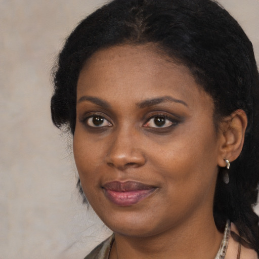 Joyful black young-adult female with long  brown hair and brown eyes