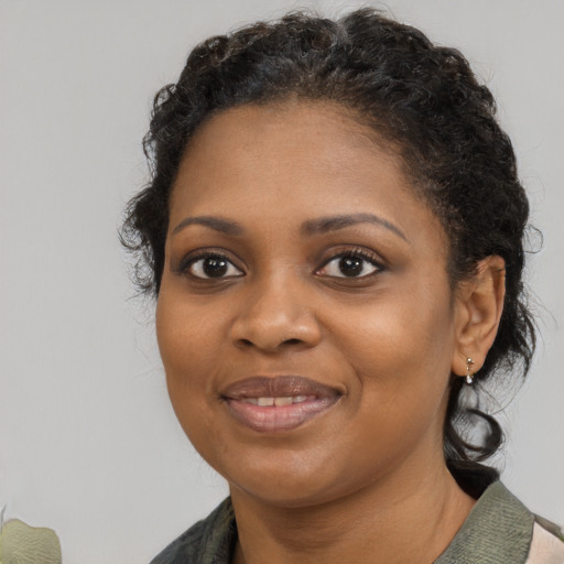 Joyful black young-adult female with medium  brown hair and brown eyes