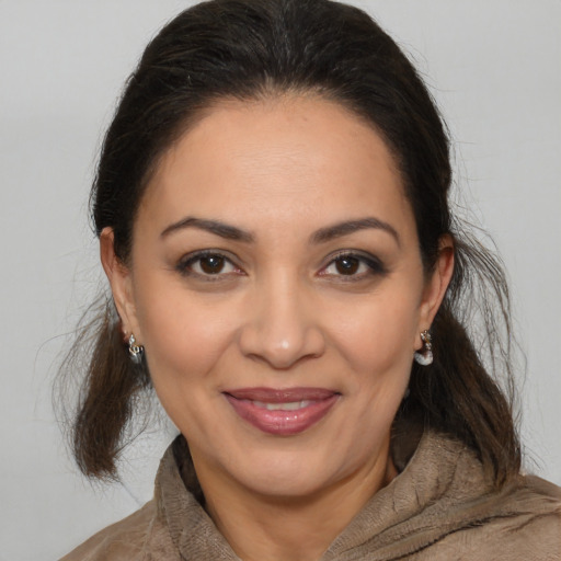 Joyful latino young-adult female with medium  brown hair and brown eyes