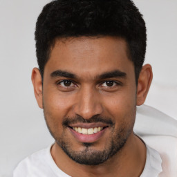 Joyful latino young-adult male with short  brown hair and brown eyes