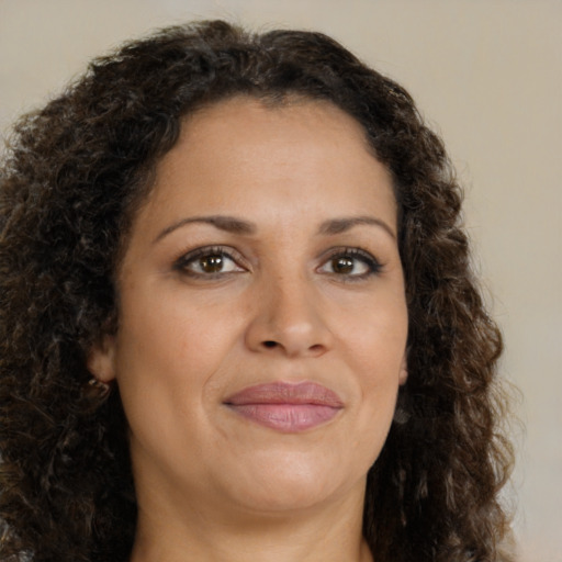 Joyful latino adult female with medium  brown hair and brown eyes