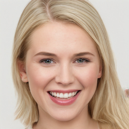 Joyful white young-adult female with long  brown hair and blue eyes