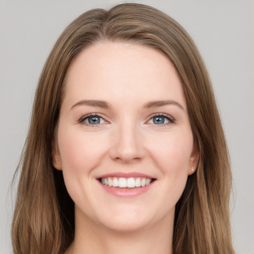 Joyful white young-adult female with long  brown hair and grey eyes