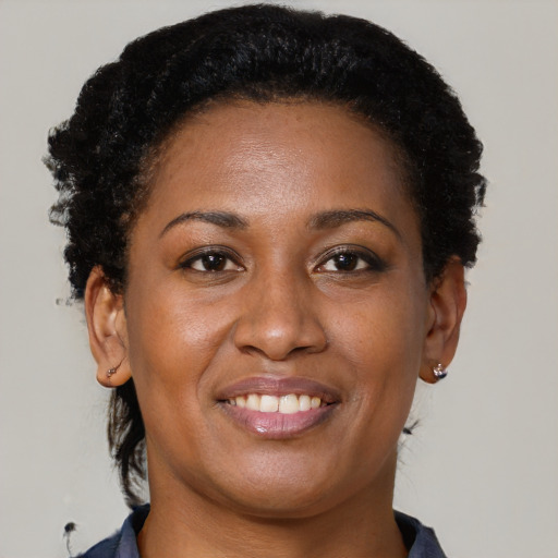 Joyful black young-adult female with short  brown hair and brown eyes