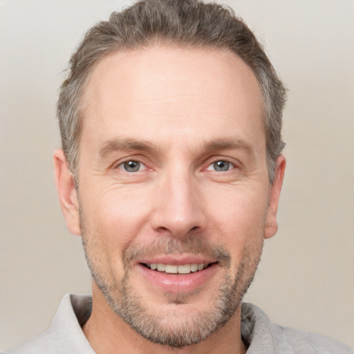 Joyful white adult male with short  brown hair and grey eyes