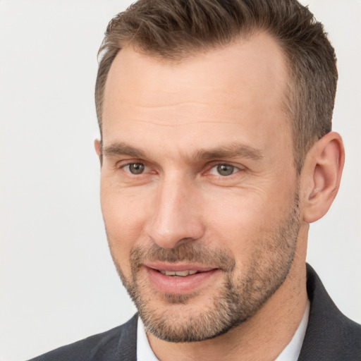 Joyful white adult male with short  brown hair and brown eyes