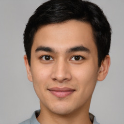 Joyful asian young-adult male with short  brown hair and brown eyes