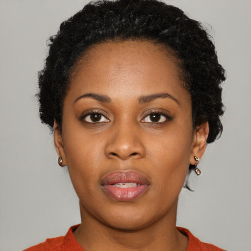 Joyful black young-adult female with short  brown hair and brown eyes