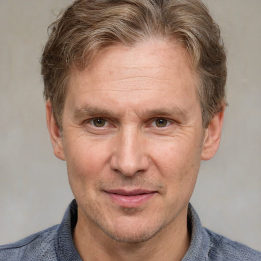 Joyful white adult male with short  brown hair and blue eyes