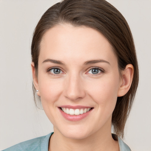 Joyful white young-adult female with medium  brown hair and grey eyes