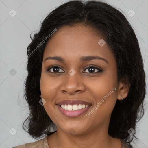 Joyful black young-adult female with long  brown hair and brown eyes