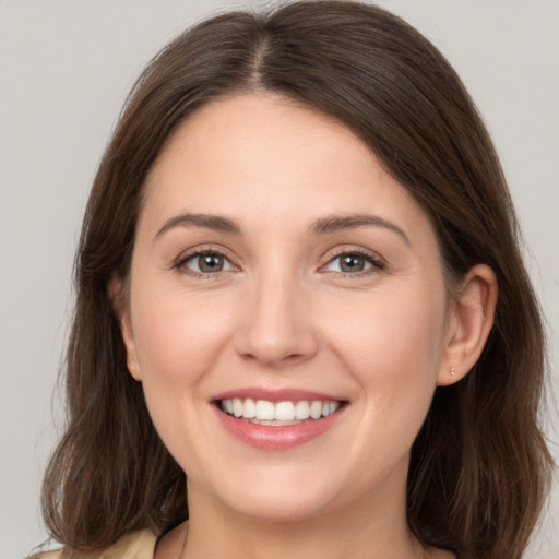 Joyful white young-adult female with medium  brown hair and grey eyes