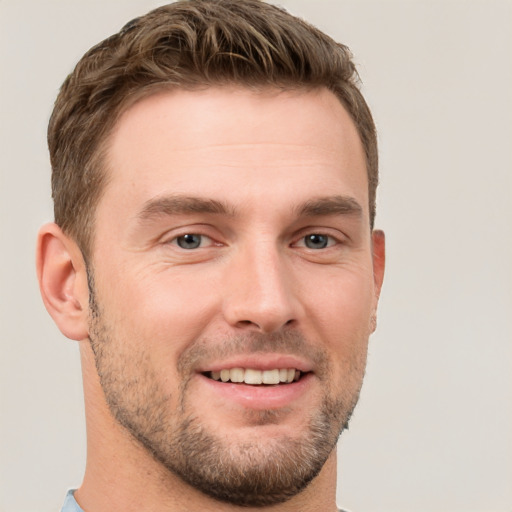 Joyful white young-adult male with short  brown hair and grey eyes