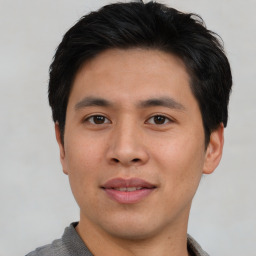 Joyful asian young-adult male with short  brown hair and brown eyes