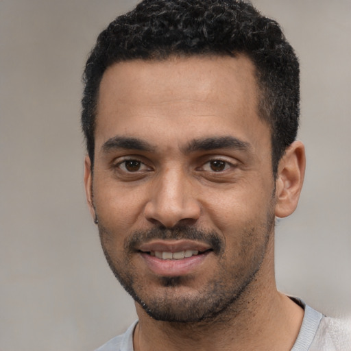 Joyful black young-adult male with short  black hair and brown eyes