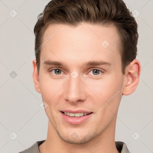 Joyful white young-adult male with short  brown hair and grey eyes