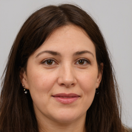 Joyful white adult female with long  brown hair and brown eyes