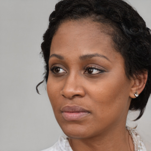 Joyful black young-adult female with medium  black hair and brown eyes