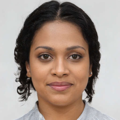 Joyful black young-adult female with long  brown hair and brown eyes