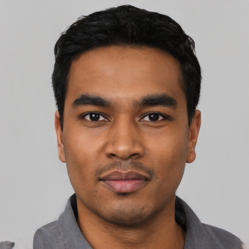 Joyful latino young-adult male with short  black hair and brown eyes