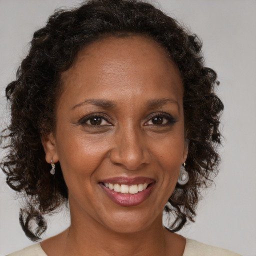 Joyful black adult female with medium  brown hair and brown eyes