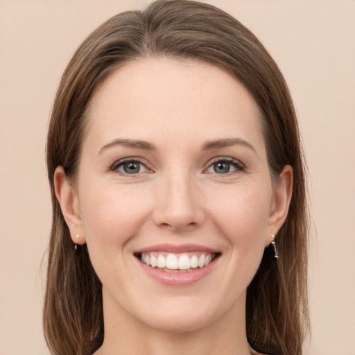 Joyful white young-adult female with long  brown hair and grey eyes