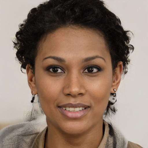 Joyful black young-adult female with short  black hair and brown eyes