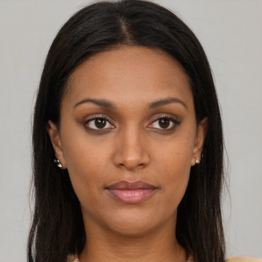 Joyful black young-adult female with long  brown hair and brown eyes