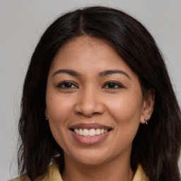 Joyful latino young-adult female with long  brown hair and brown eyes