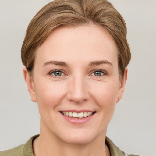 Joyful white young-adult female with short  brown hair and grey eyes