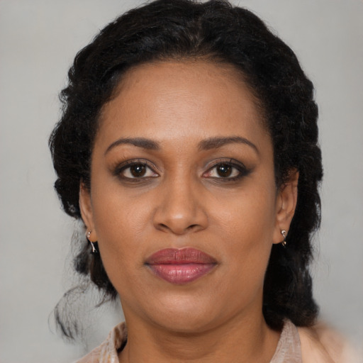 Joyful black adult female with medium  brown hair and brown eyes