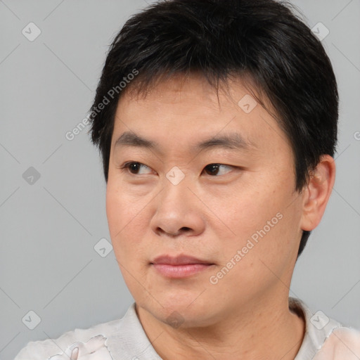 Joyful asian young-adult male with short  brown hair and brown eyes