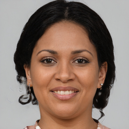Joyful latino young-adult female with medium  brown hair and brown eyes