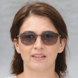 Joyful white adult female with medium  brown hair and brown eyes