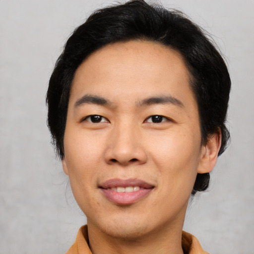 Joyful asian young-adult male with medium  black hair and brown eyes