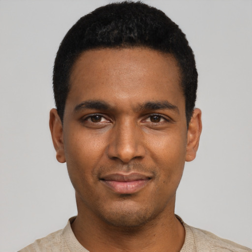 Joyful black young-adult male with short  black hair and brown eyes
