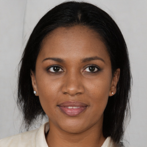 Joyful black young-adult female with long  brown hair and brown eyes