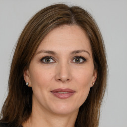 Joyful white adult female with long  brown hair and grey eyes