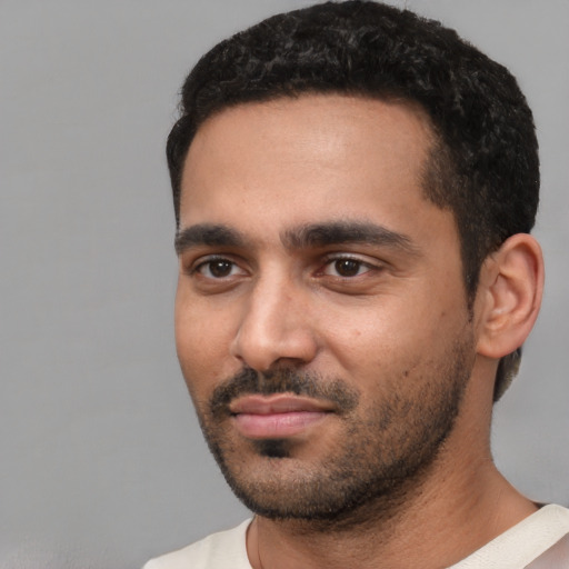 Joyful black young-adult male with short  black hair and brown eyes