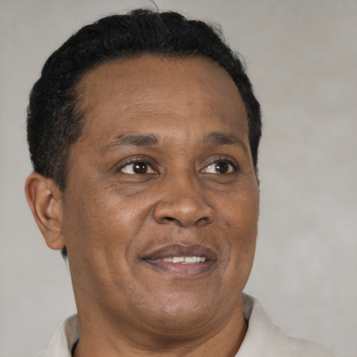 Joyful black adult male with short  brown hair and brown eyes