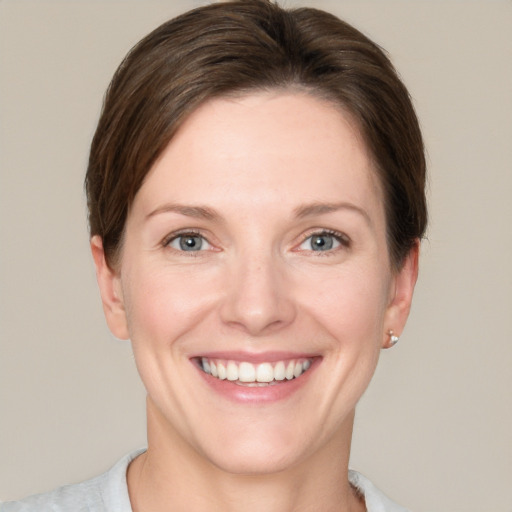 Joyful white young-adult female with short  brown hair and grey eyes