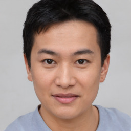 Joyful asian young-adult male with short  brown hair and brown eyes