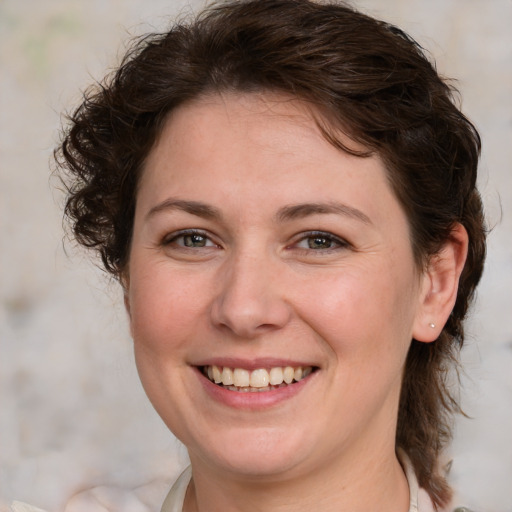 Joyful white young-adult female with medium  brown hair and green eyes